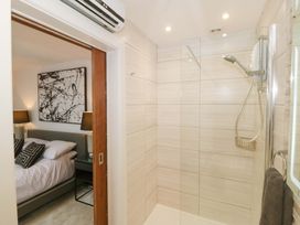 A bathroom with a shower and a view of a bedroom at Lodge Llangefni