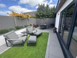 A patio with chairs and a table at Lodge in Llangefni