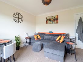 A living room with a sofa and a dining table at Golygfa in Pandy Tudur near Llanrwst