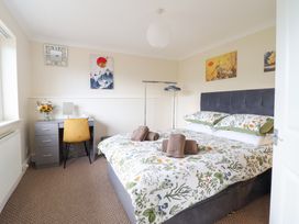 A bedroom with a bed, desk, chair and artwork at Golygfa in Pandy Tudur near Llanrwst