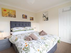 A bedroom with a bed and wall art at Golygfa in Pandy Tudur near Llanrwst