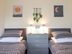 A bedroom with two beds and wall art at Golygfa in Pandy Tudur near Llanrwst