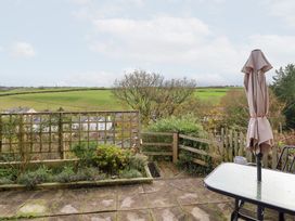 A garden with a table and umbrella overlooking fields at Golygfa Pandy Tudur near Llanrwst