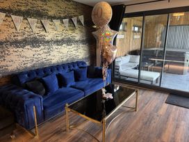 A living room with a blue sofa balloons and a black glass coffee table at Wayside Lodge in Blackpool