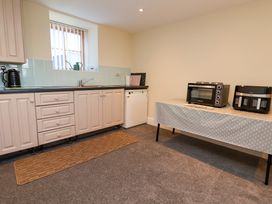 A kitchen with cabinets sink dishwasher and appliances on a table at Walnut Cottage in Halkyn