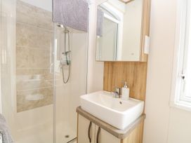 A bathroom with a shower enclosure a sink with a soap dispenser and a mirror cabinet at 75 Foxburrow Hang in Fritton