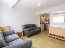 A living room with a sofa and a kitchen area at 440 California Sands