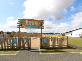 A crazy golf area with a sign at Oasis Crazy Golf in 