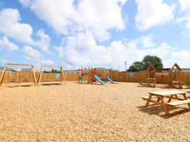 An outdoor play area with swings and slides at 440 California Sands