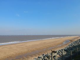 A beach view with wind turbines in the distance at 440 California Sands