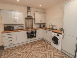 A kitchen with cabinets and appliances at The Newborough Apartment 3 in Scarborough