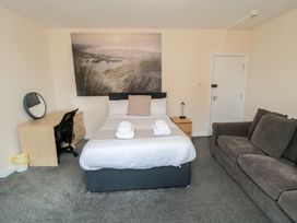 A bedroom with a bed and a couch at The Newborough Apartment 3 in Scarborough