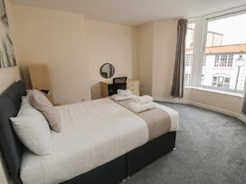 A bedroom with a bed, desk, and window at The Newborough Apartment 3 Scarborough