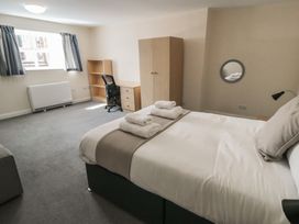 A bedroom with a bed and wardrobe at The Newborough Apartment 4 Scarborough