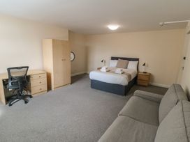 A bedroom with a bed, desk and sofa at The Newborough Apartment 4 Scarborough
