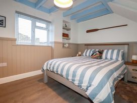 A bedroom with a bed and shelves at Puffin Cottage in Tintagel