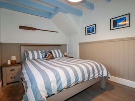 A bedroom with a bed and bedside table at Puffin Cottage in Tintagel