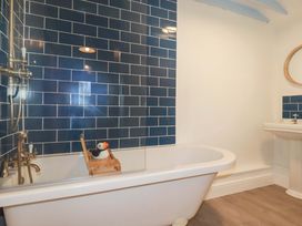A bathroom with a bathtub and sink at Puffin Cottage Tintagel