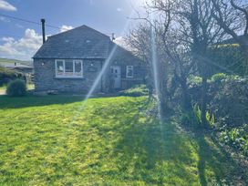 A house with grass and trees outside Puffin Cottage in Tintagel