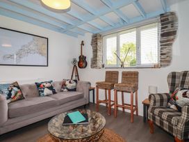 A living room with a map on the wall and a guitar at Puffin Cottage in Tintagel