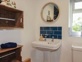 A bathroom with a sink and mirror at Puffin Cottage in Tintagel