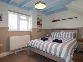 A bedroom with a bed and shelves at Puffin Cottage in Tintagel
