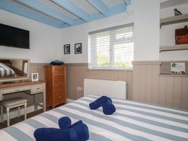 A bedroom with a bed and a television at Puffin Cottage in Tintagel