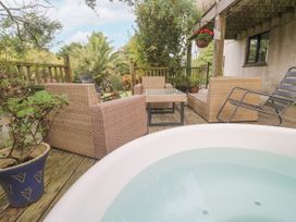 An outdoor area with a hot tub and seating at 6 The Links Praa Sands
