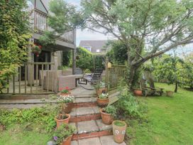 A garden with decking, chairs, and potted plants at 6 The Links Praa Sands