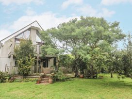 A house with a tree and decking in the garden at 6 The Links Praa Sands