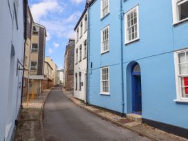 A narrow street with buildings on both sides including a blue building with white windows at Harbour Hideaway in Dartmouth