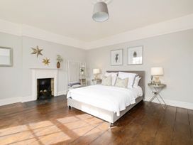 A bedroom with a bed a fireplace bedside tables and two framed pictures on the wall at Holmer House Farm in Holmer near Hereford