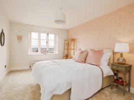 A bedroom with a bed and pink pillows next to a side table with a lamp at Holmer House Farm in Holmer near Hereford