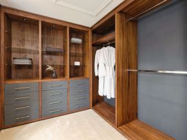 A walk in closet with wooden shelves drawers and hanging robes at Holmer House Farm Holmer near Hereford