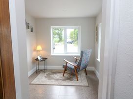 A snug area with a chair, table, and lamp at Valley View House in Kealkill, County Cork