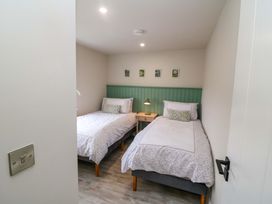 A bedroom with two beds and a nightstand at Valley View House, Kealkill, County Cork