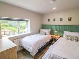 A bedroom with two beds and a window at Valley View House in Kealkill, County Cork