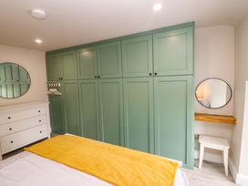 A bedroom with a green wardrobe and a mirror at Valley View House, Kealkill, County Cork