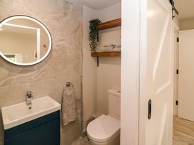 A bathroom with a sink, toilet, and shelves at Valley View House in Kealkill, County Cork