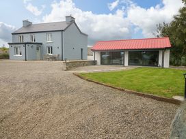 A house with a gravel driveway and a red roof at Valley View House in Kealkill, County Cork