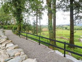 A gravel pathway with a wooden fence alongside trees at Valley View House in Kealkill, County Cork