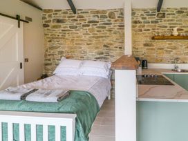 A bedroom with a bed and kitchen area at The Stall near Kealkill, County Cork