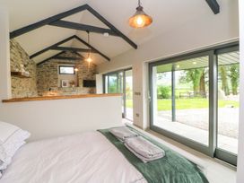 A bedroom featuring a bed with towels and large windows at The Stall near Kealkill, County Cork