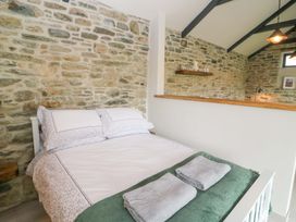 A bedroom with a bed and stone wall at The Stall near Kealkill, County Cork