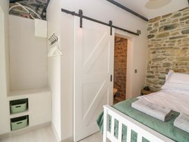 A bedroom with a bed and sliding door at The Stall near Kealkill, County Cork