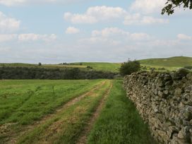 A path alongside a stone wall in a field at Howgill Head Kendal