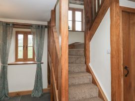 A staircase with a window and curtains in a hallway at Howgill Head in Kendal