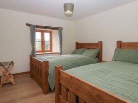 A bedroom with two beds and a window at Howgill Head in Kendal