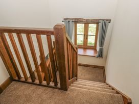 A staircase with a window and curtains at Howgill Head in Kendal