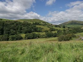 A rural landscape with hills and trees at Howgill Head in Kendal